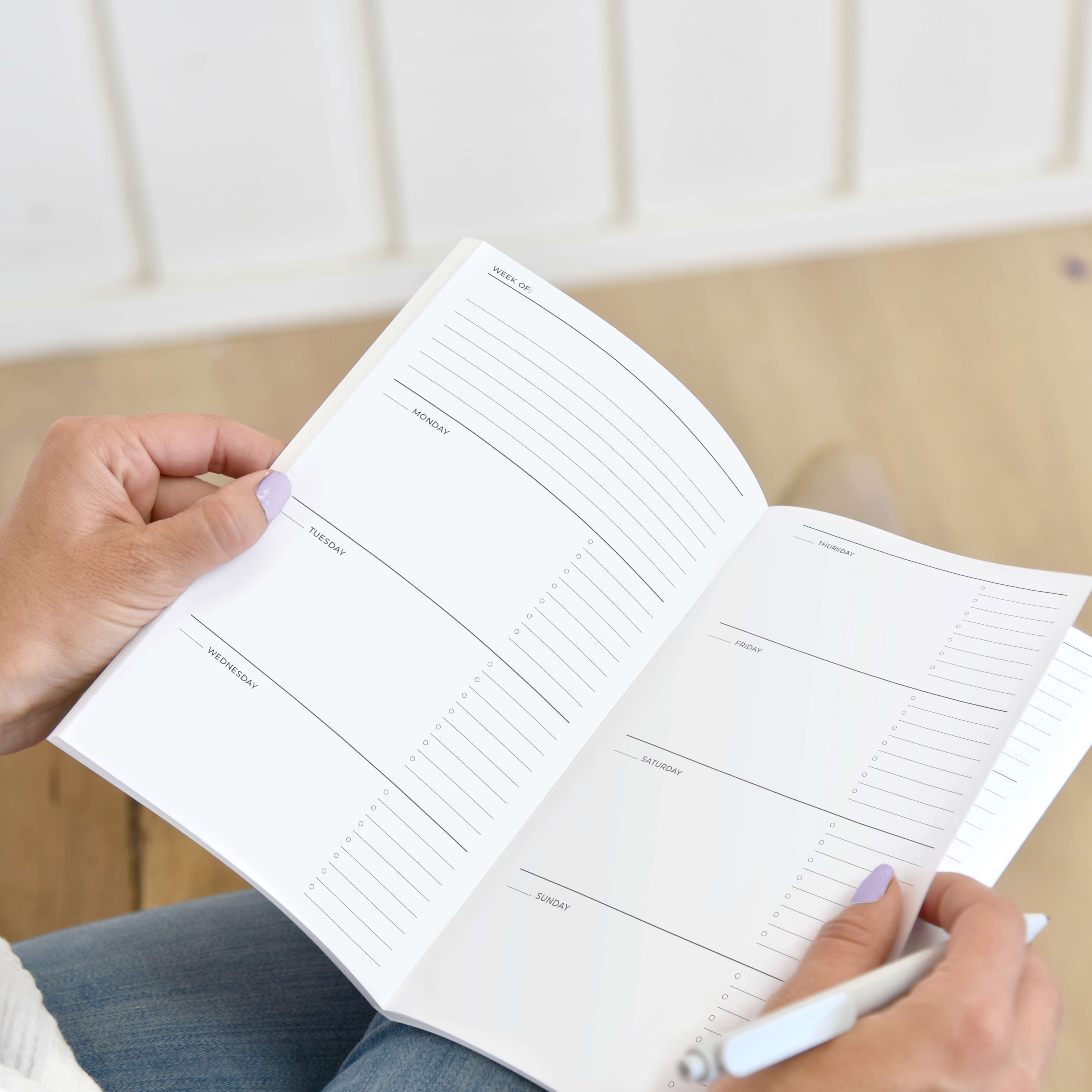 Woman holding a medium Undated Two-Sided Days Saddle Stitched Planner Woman holding a medium Undated Two-Sided Days Saddle Stitched Planner