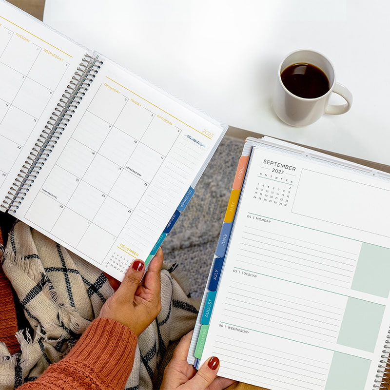 2 people with modern planners open, lifestyle living room scene