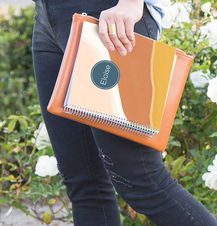 Woman carrying bag and college student planner with customized cover.