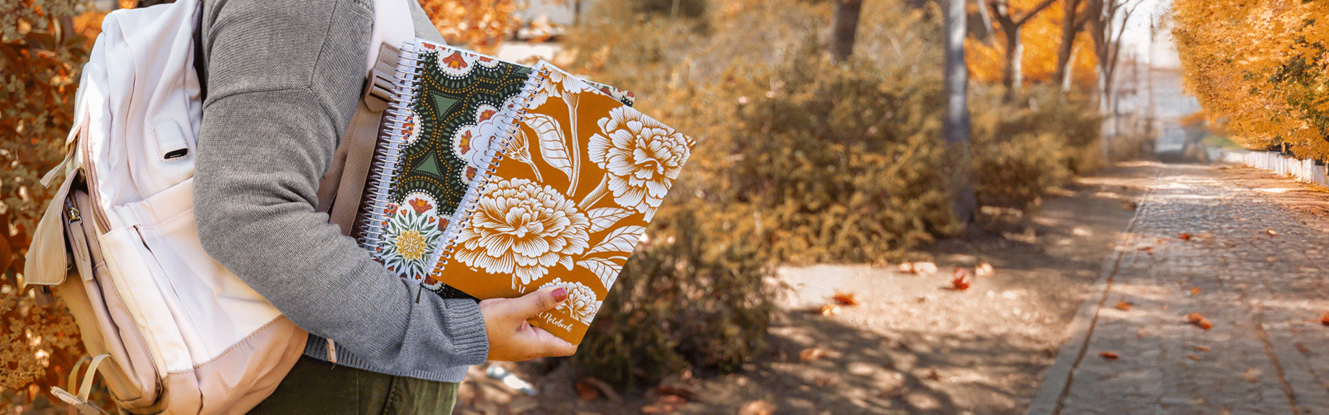 Woman wearing a white backpack holding two planners with marigold cover and 