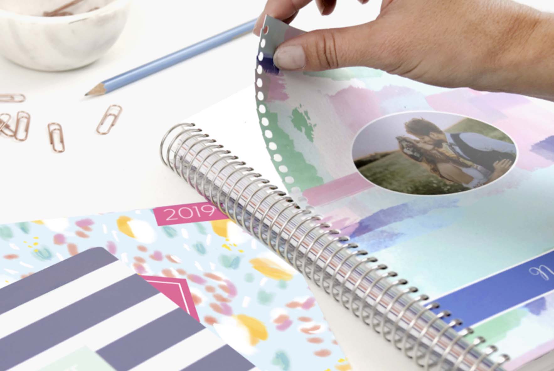 Someone snapping on a customized interchangeable cover to their planner Someone snapping on a customized interchangeable cover to their planner