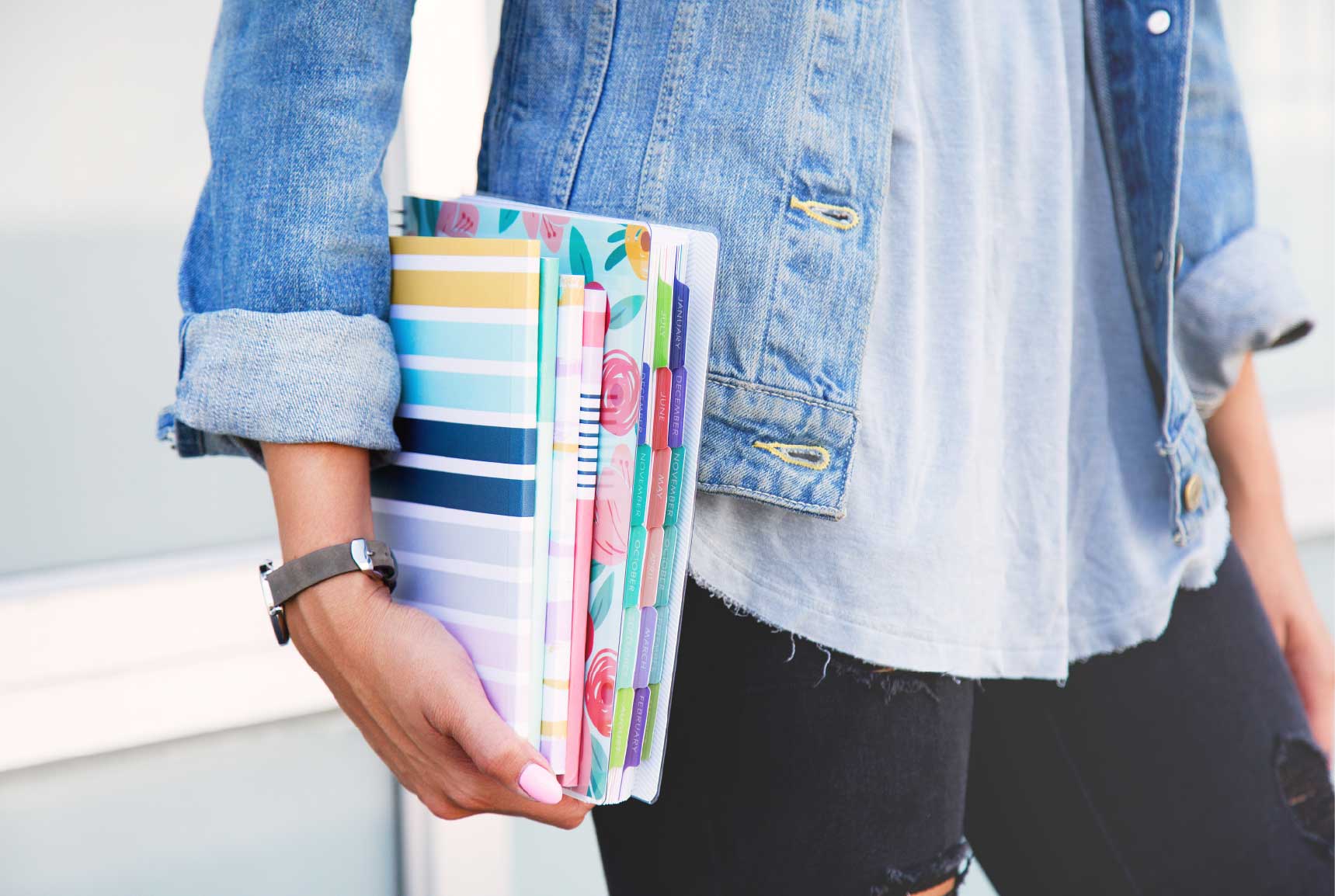 Girl carrying a student planner and 4 personalized journals.