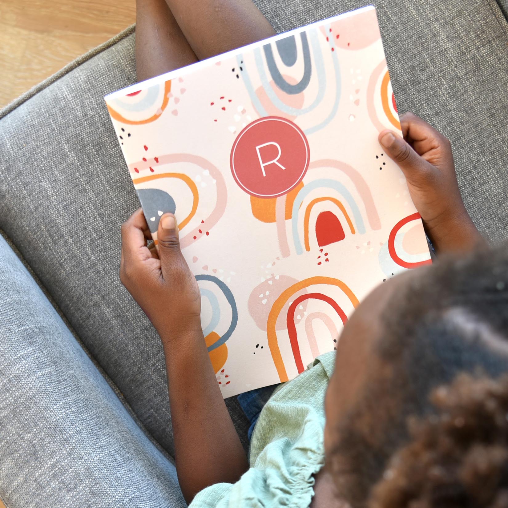 girl holding an Adventure Book while sitting on a couch girl holding an Adventure Book while sitting on a couch