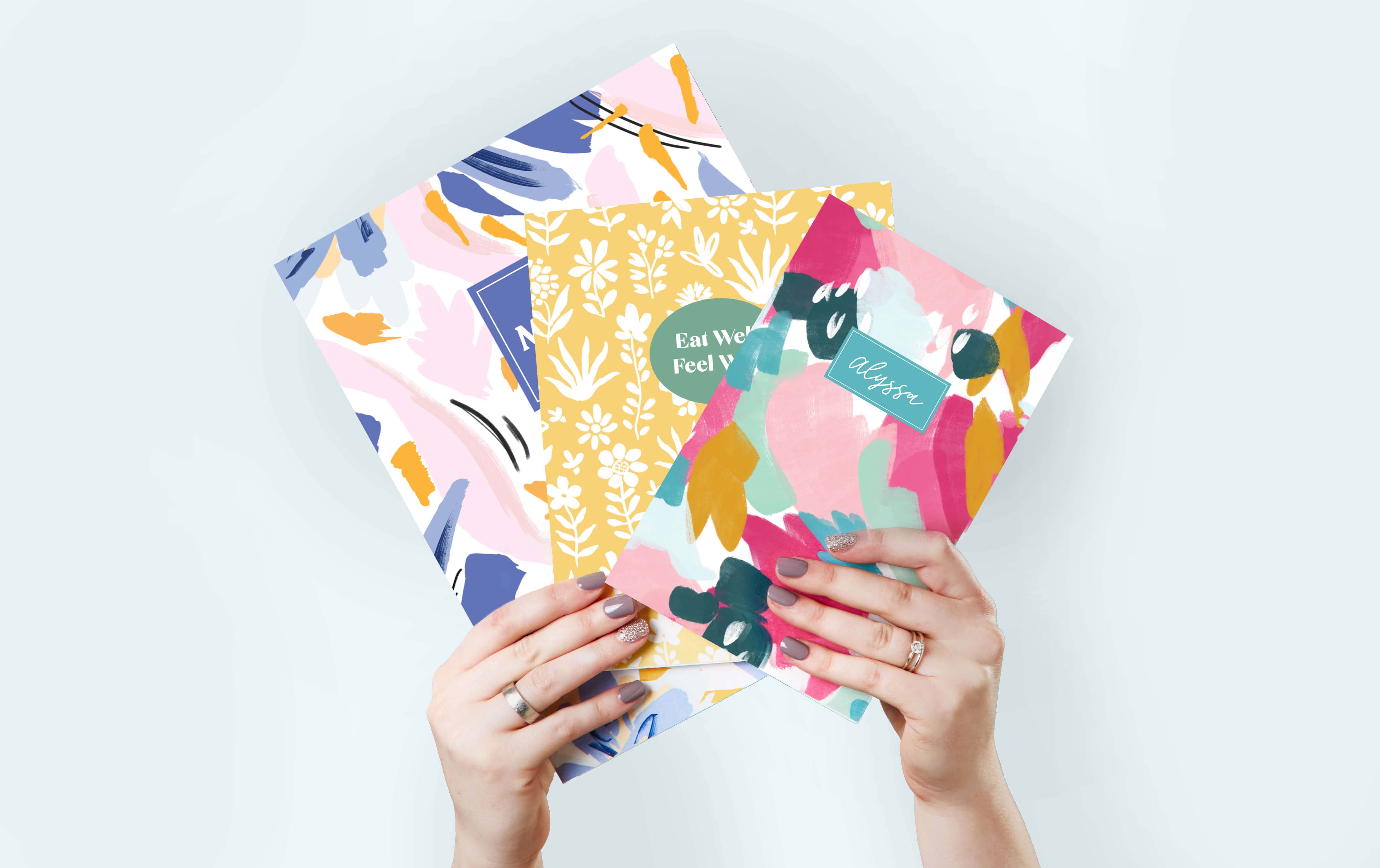 Woman holding small, medium, and large saddle stitched planners Woman holding small, medium, and large saddle stitched planners