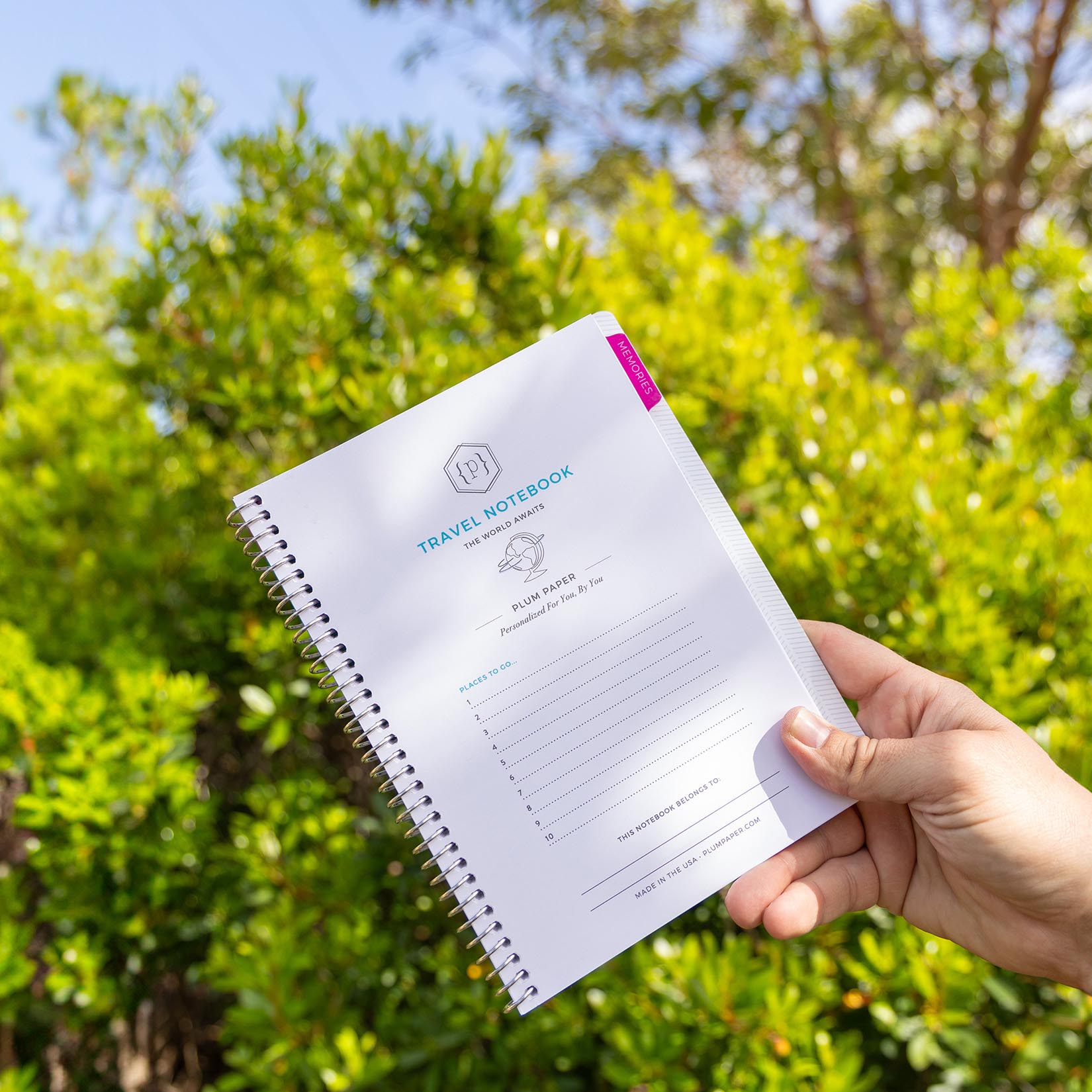 Person holding a custom travel notebook outside
