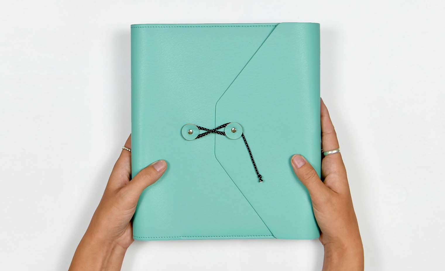 Woman holding a turquoise planner folio