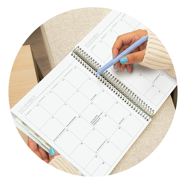 Person writing in a Plum Paper monthly planner spread — custom 2026 handmade planner designed to help track appointments, goals, and daily organization. Person writing in a Plum Paper monthly planner spread — custom 2026 handmade planner designed to help track appointments, goals, and daily organization.