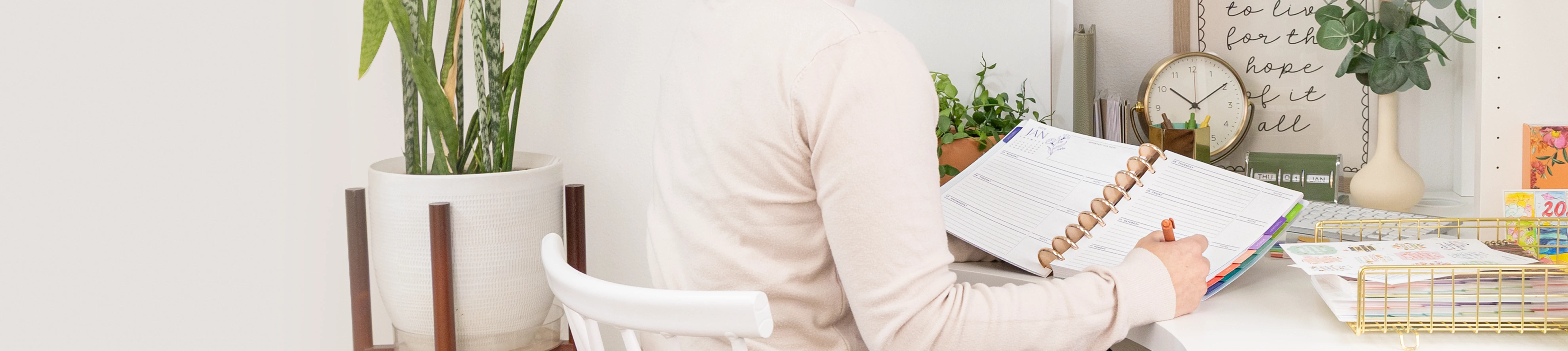Woman sitting at a desk, writing in her Soft Florals Horizontal Planner