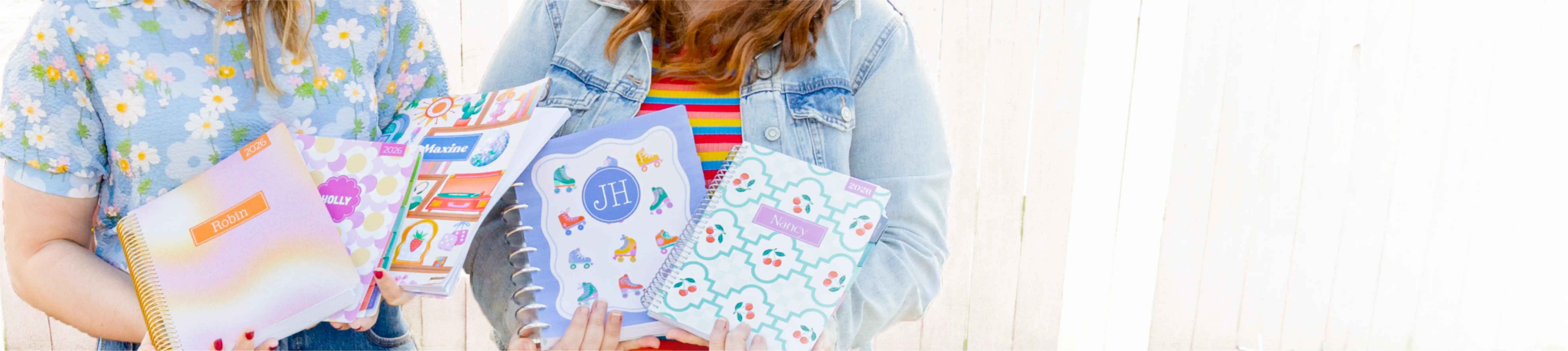 two women holding planners outside two women holding planners outside